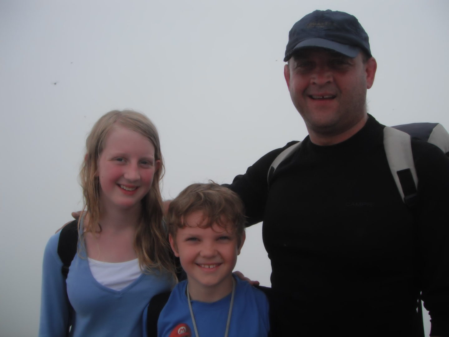 Asa, Xene and Lochlan at the summit of Mount Snowdon in cloud
