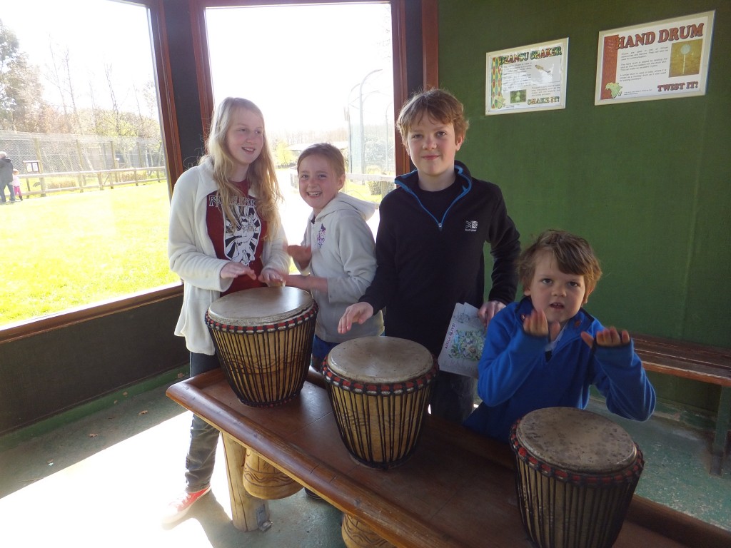 Children playing bongos in a hut at Africa Alive