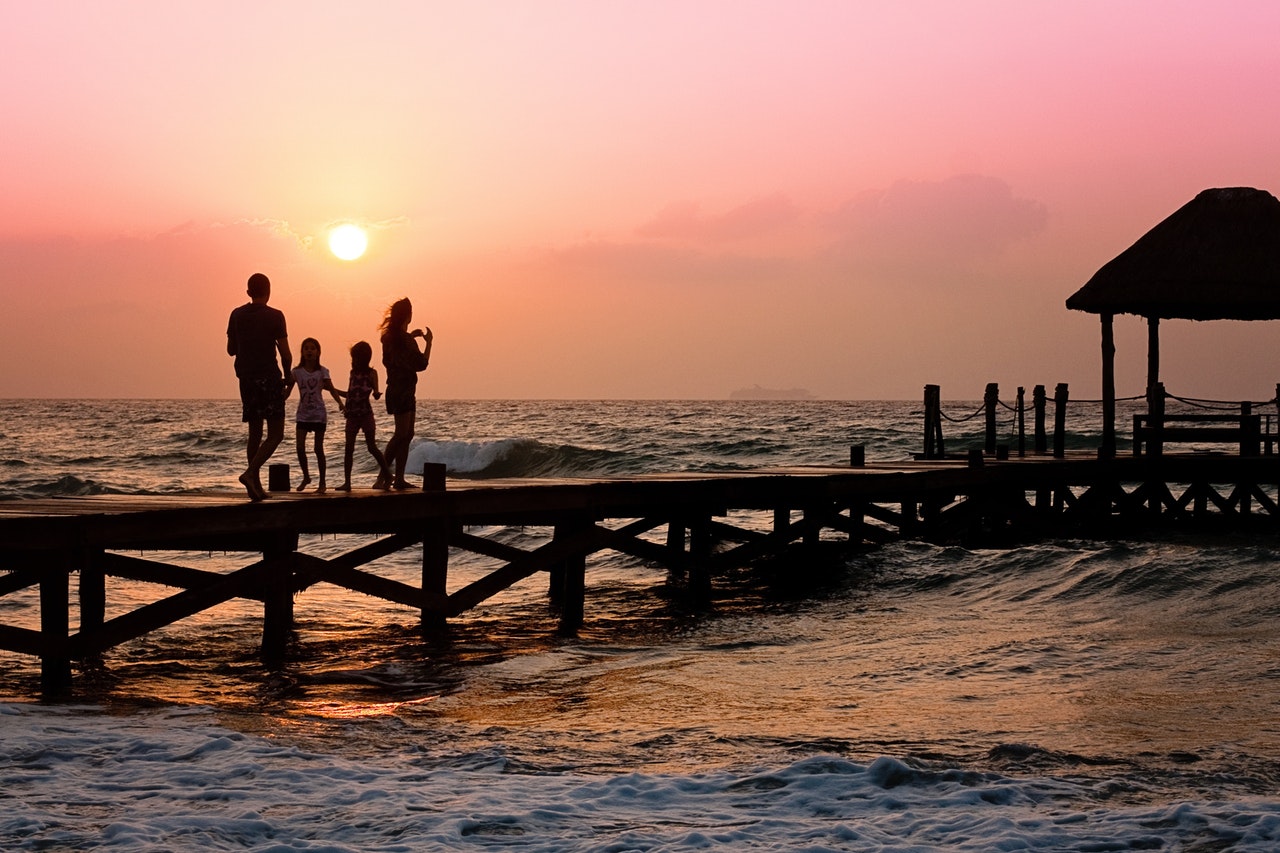 mum, dad, two kids on a boardwalk family holidays are magical