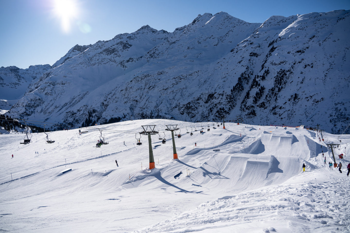 Large snowpark with kickers and rails in St.Anton am Arlberg on a sunny day.